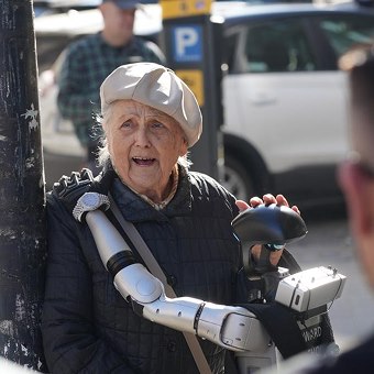 An elderly Warsaw resident talking with Edward Warchocki, her hand resting on his head